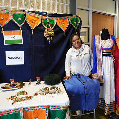 Merlian Trince with India cultural display, flags, jewelry, dresses