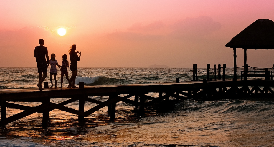 family walking on pier at sunset