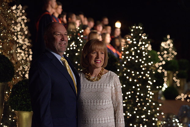 Steven and Janet Leath pose next to illuminated Christmas trees.