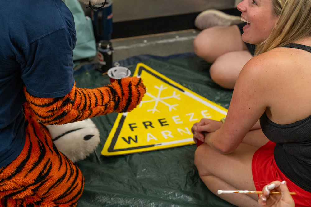 Aubie helping committee members create a Freeze Warning sign