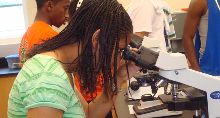 student with microscope