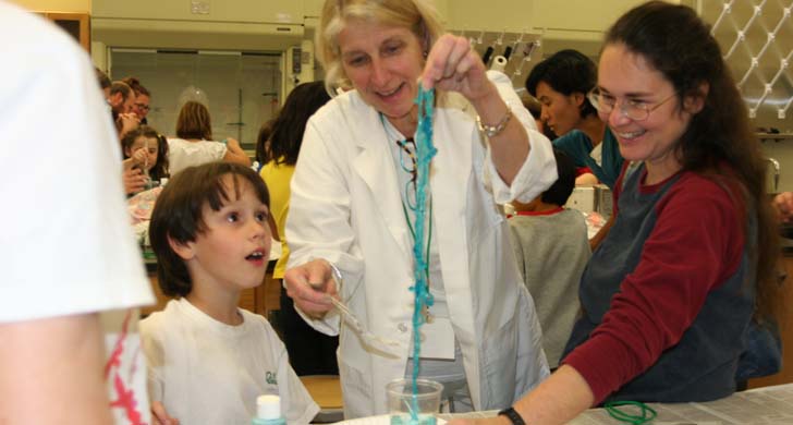 student watching teacher make slime