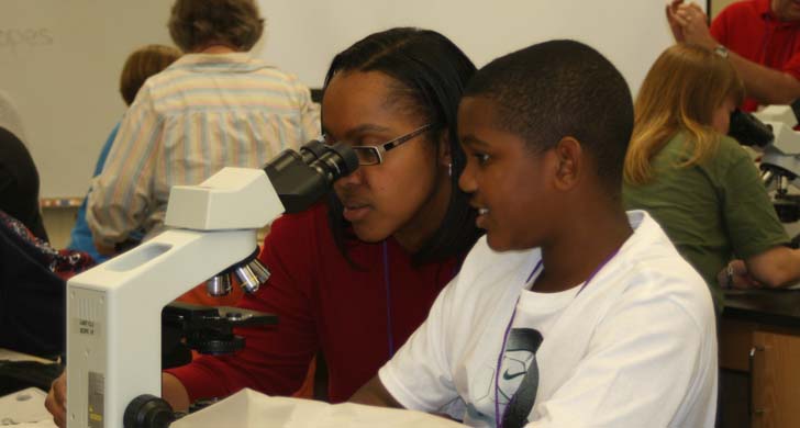 student with microscope