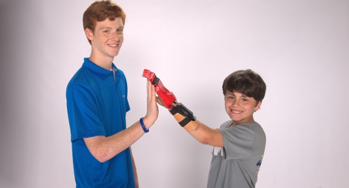 Ethan Brown giving Zach McCleery a high five using his prosthetic hand