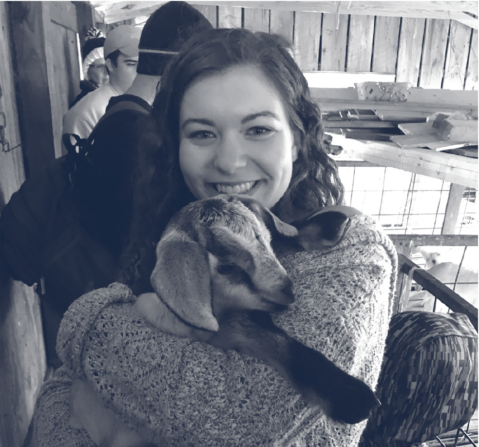 Natalie Williams holds a baby goat while on a Microbiology Club Field Trip.