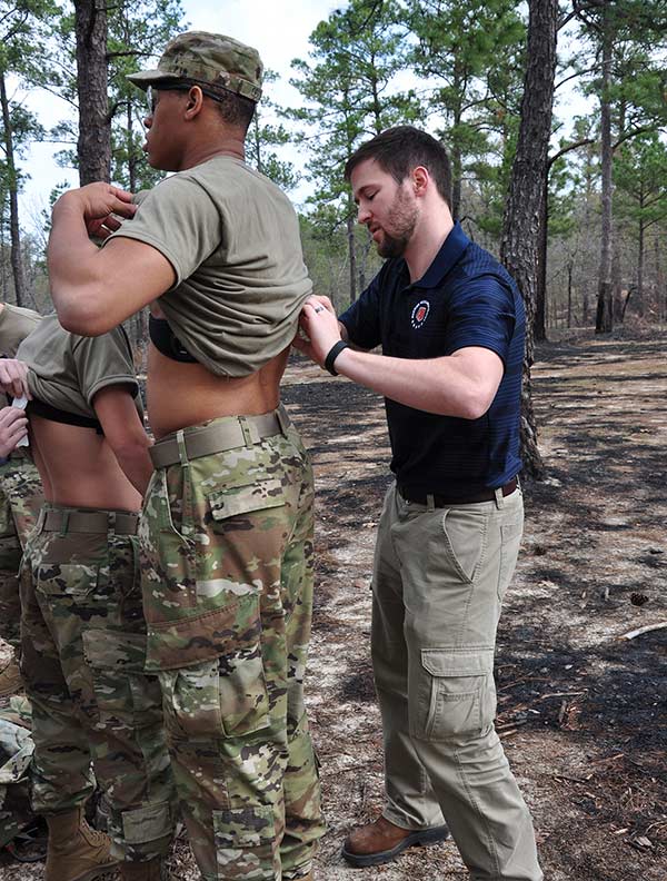 Doctoral student Jeremy McAdam applies a physiological monitor on a soldier.