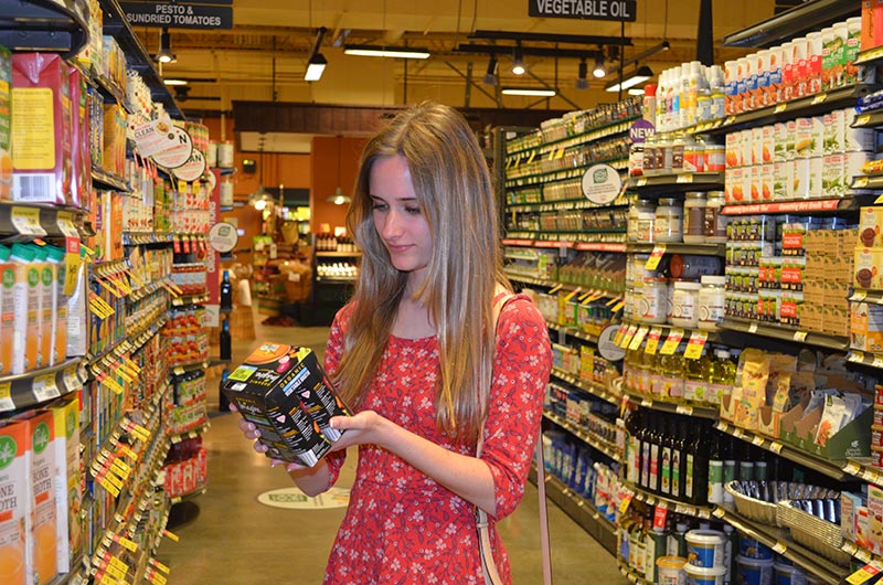 A girl looks at items in a grocery story.
