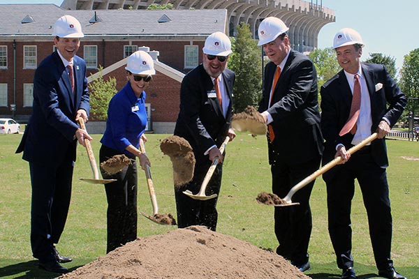 Auburn University President Jay Gogue and four others use shovels to scoop dirt during the groundbreaking ceremony for the new business building.