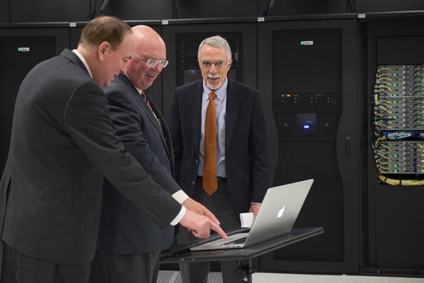Jay Gogue, Timothy Boosinger and Nicholas Giordano push the button to start Auburn’s supercomputer.