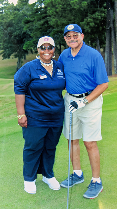 Congressman Sanford Bishop and Dr. Stacey Nickson pose for photo on the golf course.