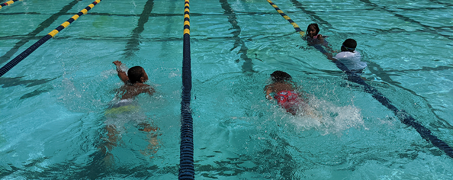 Two boys swim laps in swimming pool