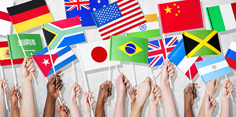 Multicolored hands holding flags from different countries