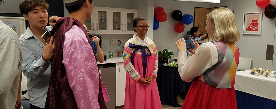 Students try on traditional Korean clothing at Korea Corner's Chuseok celebration