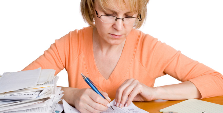 Woman sitting at table working on tax documents