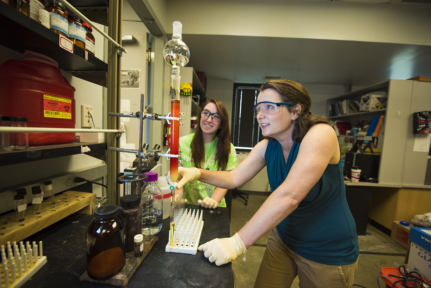 Anne Gorden working in the lab with student assisting