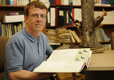 Geoffrey Hill among birds in cages