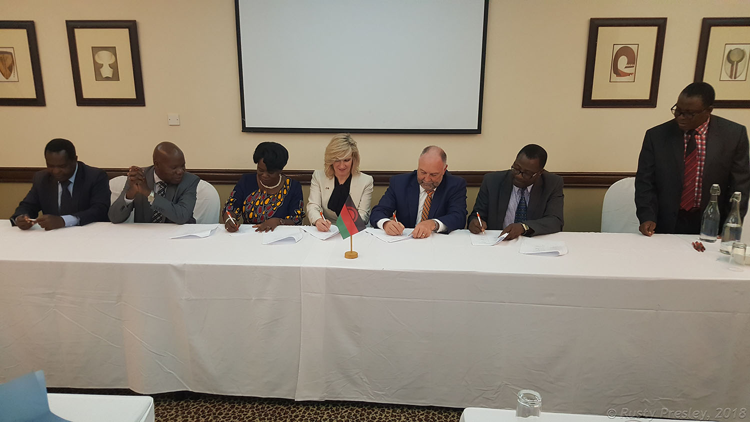 President Leath and others at a table signing papers