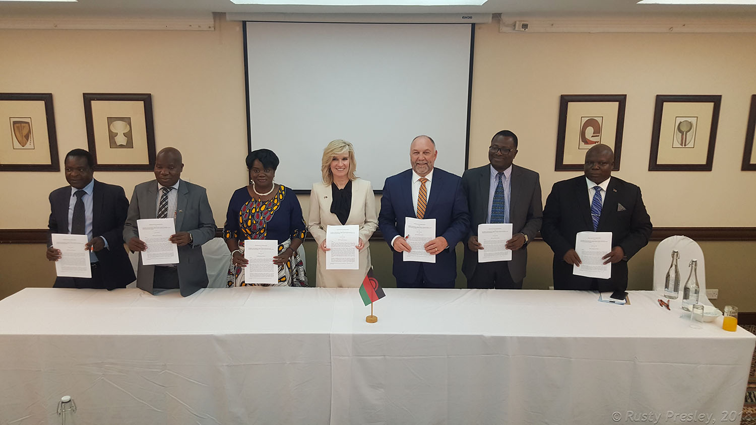 President Leath and others standing behind a table holding papers