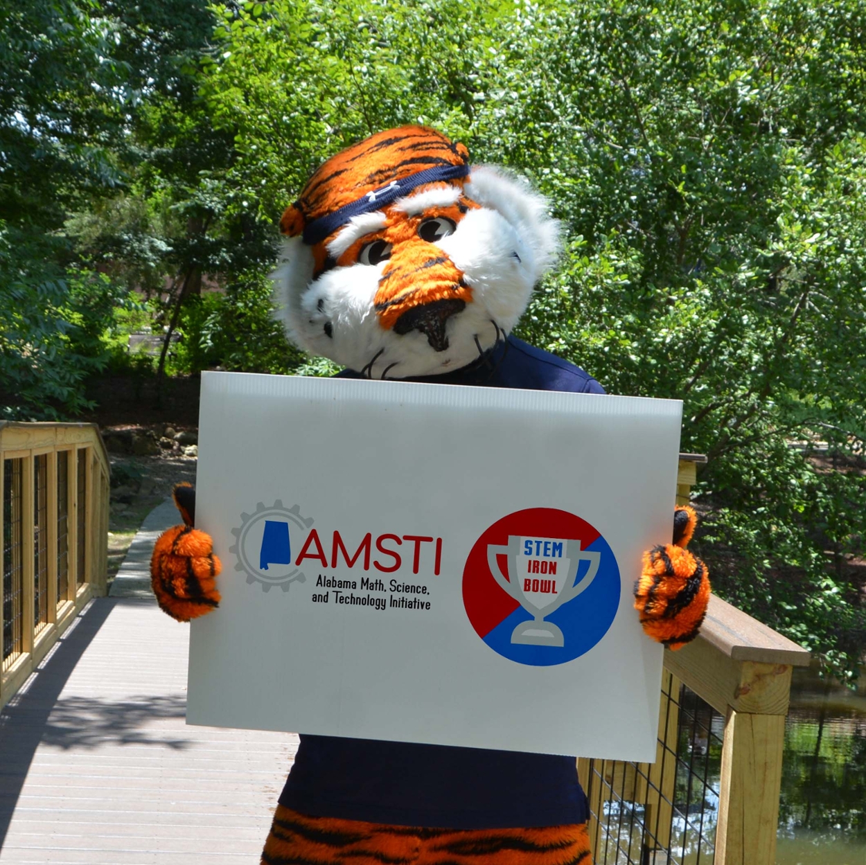 Aubie holding a sign that says AMSTI Iron Bowl