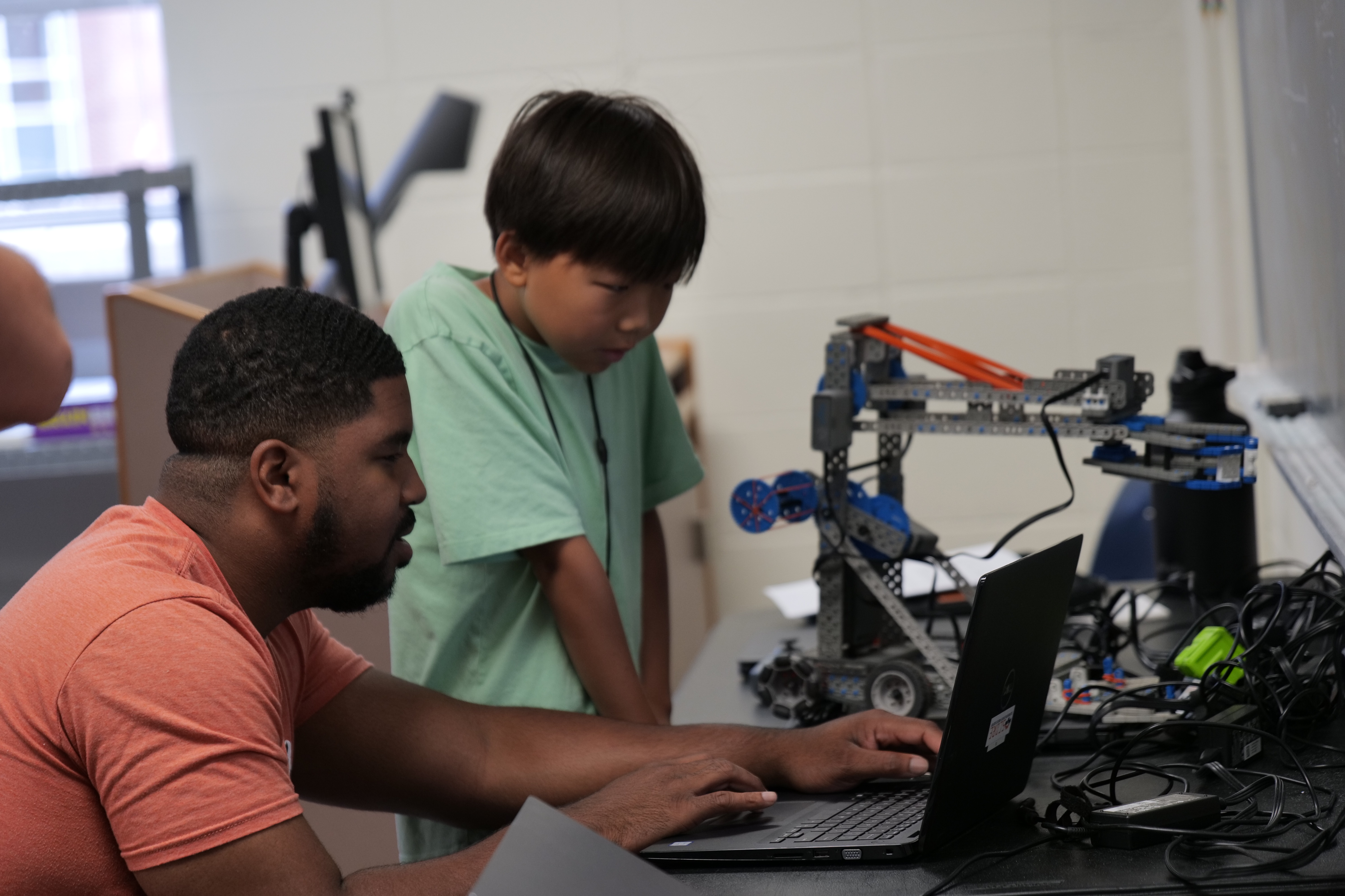 Tre Knight shows a camp participant code for his robot.