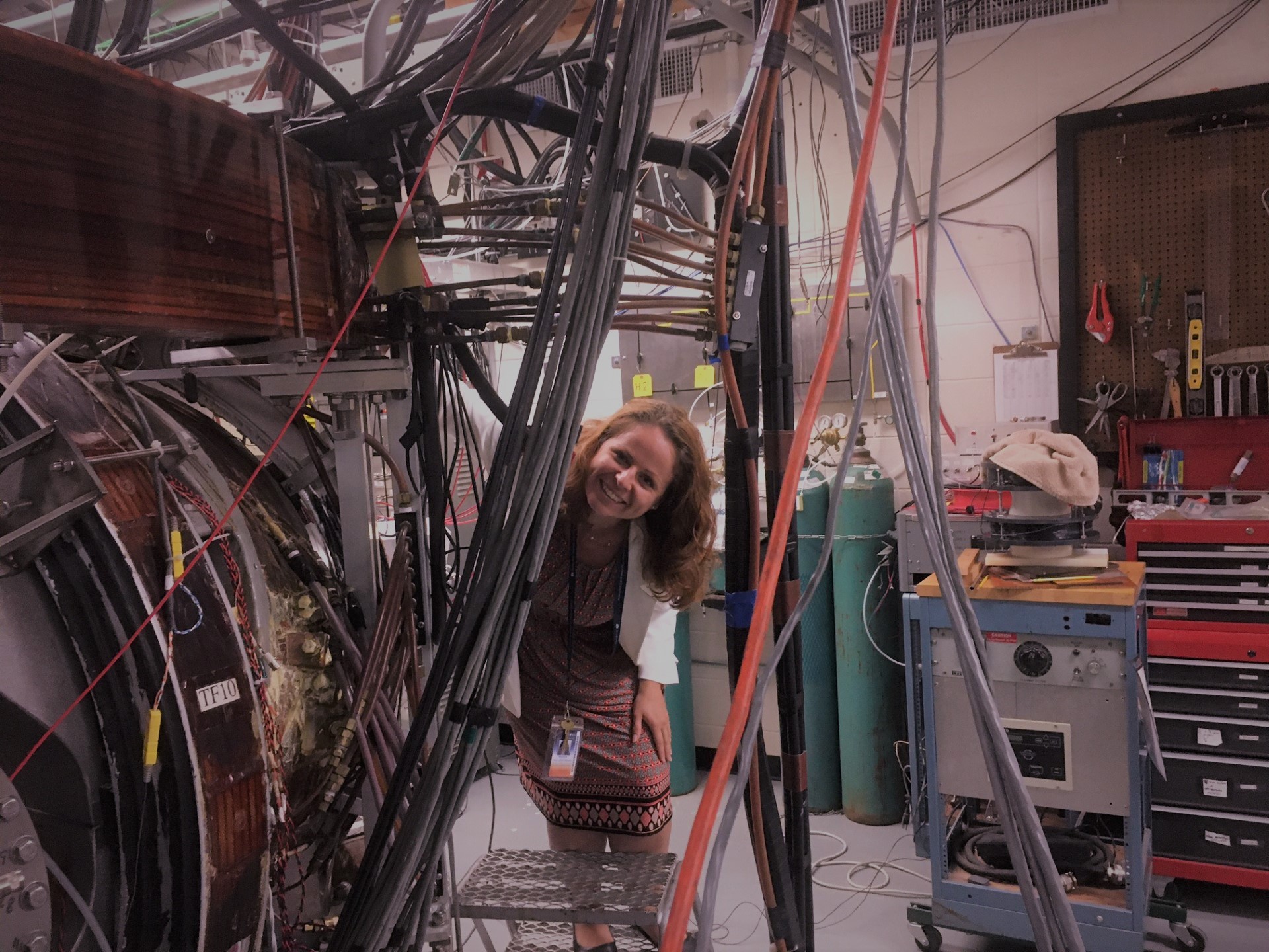 Evdokiya Kostadinova standing by the Compact Toroidal Hybrid device at the Auburn University's Physics Department.