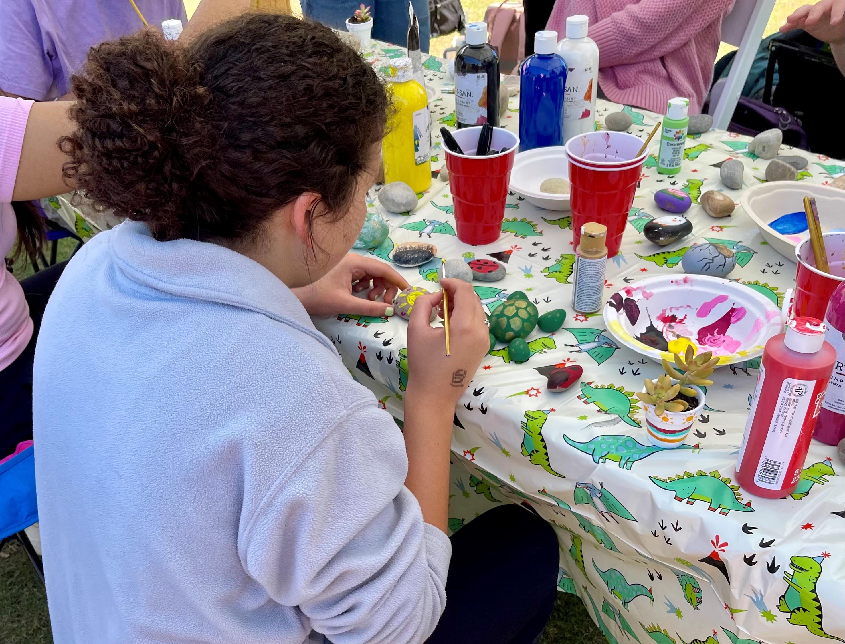Students painting rocks to resemble flowers and animals.