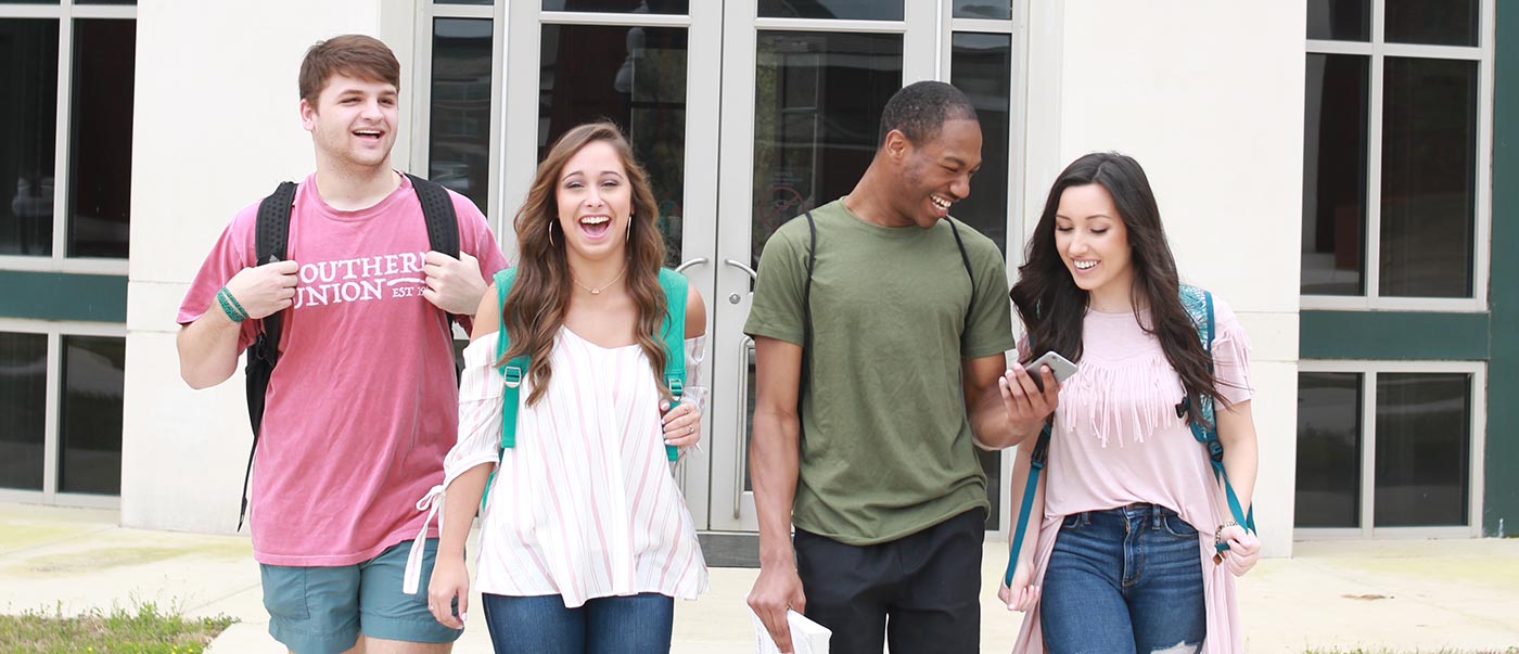 Four students walk down stairs.