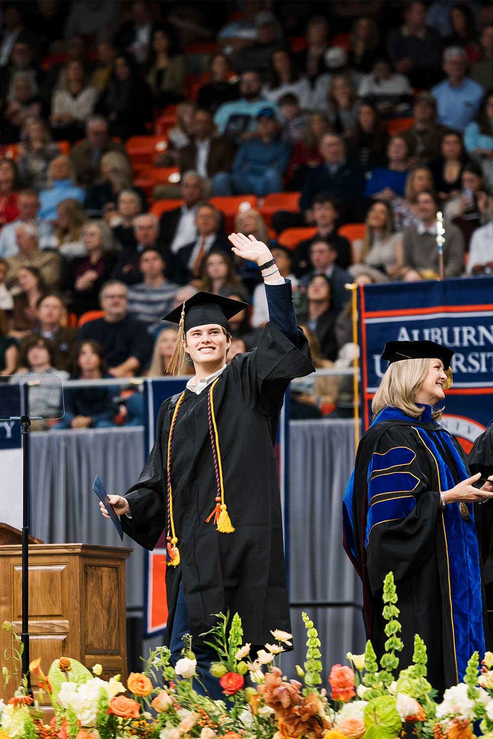 Fall 2025 Commencement student waving on stage