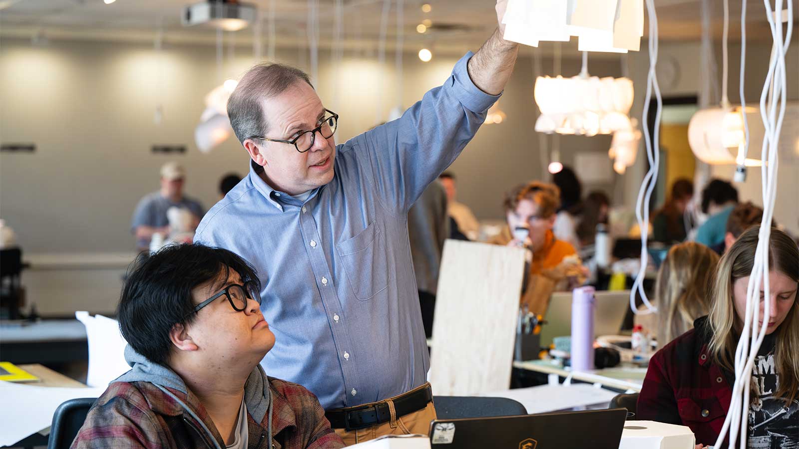 Faculty and student working on light fixtures