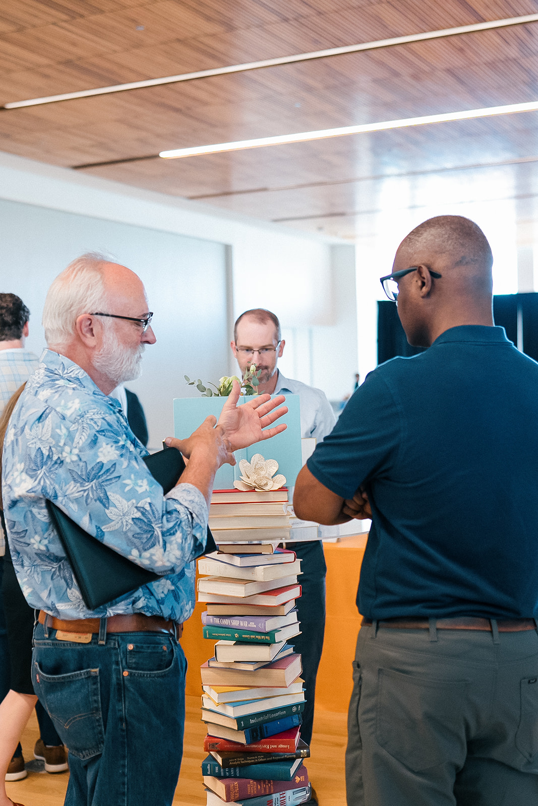 Promotion and Tenure 2024-2025 attendees talking around book table