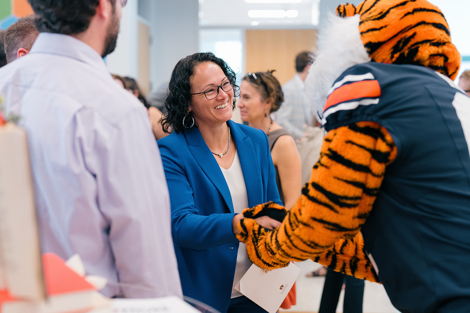 Promotion and Tenure 2024-2025 attendee shaking Aubie's hand