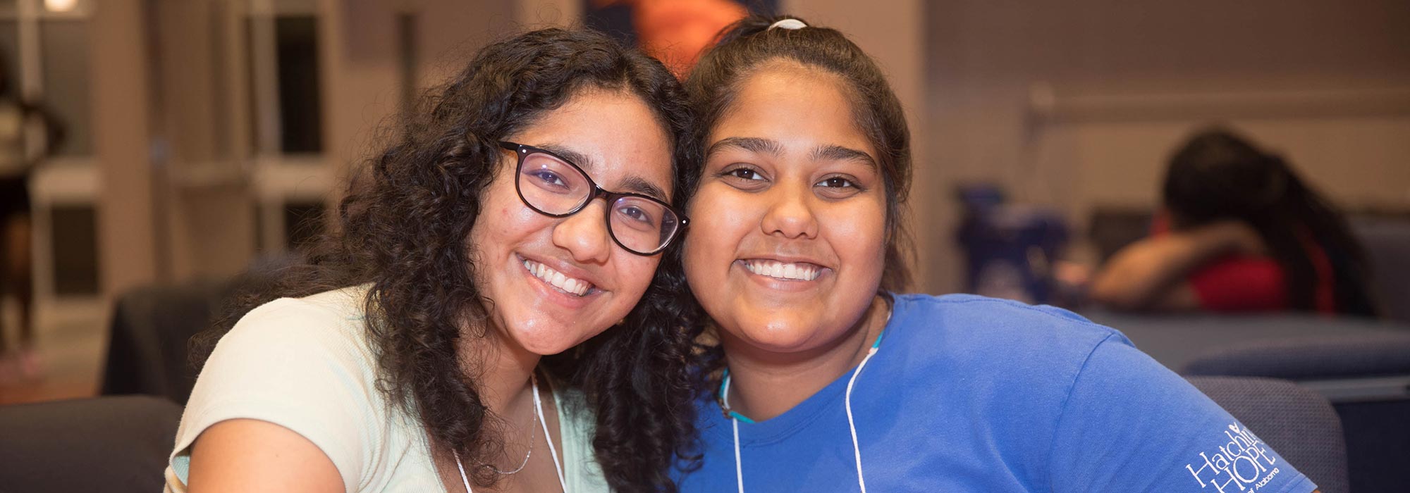 Two students pose for a photograph