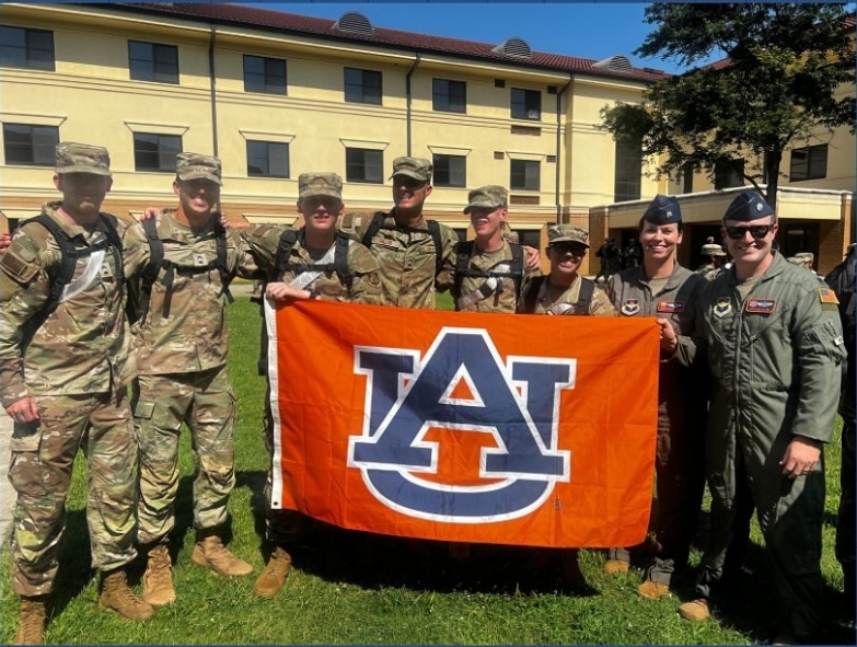 Group of cadets holding 5th cadet wing pennant