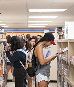 Students looking for course material on shelves.