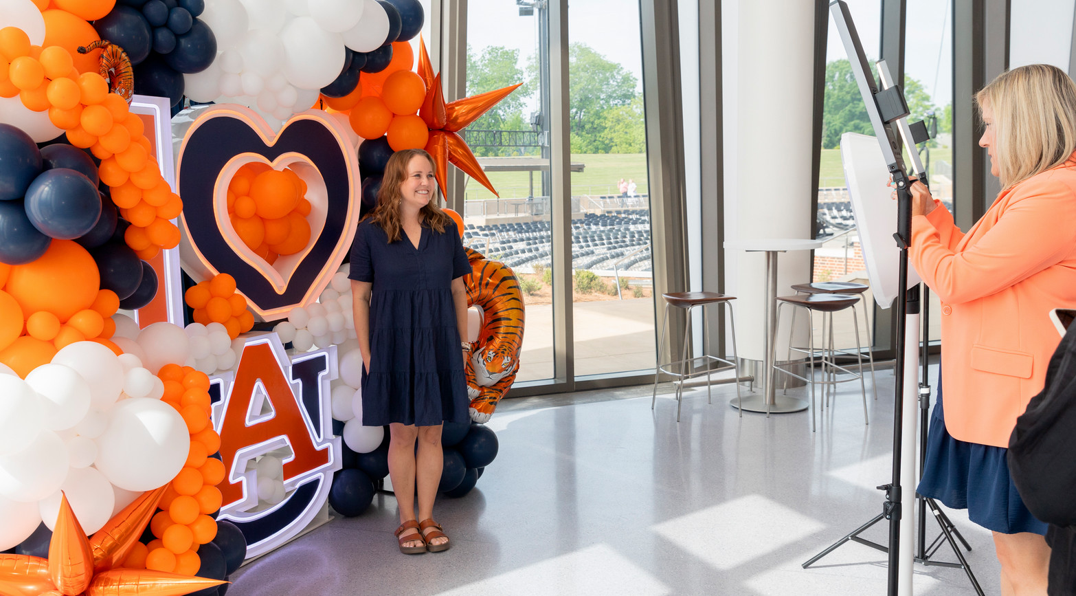 lady posing for a photo in front of a balloon arch