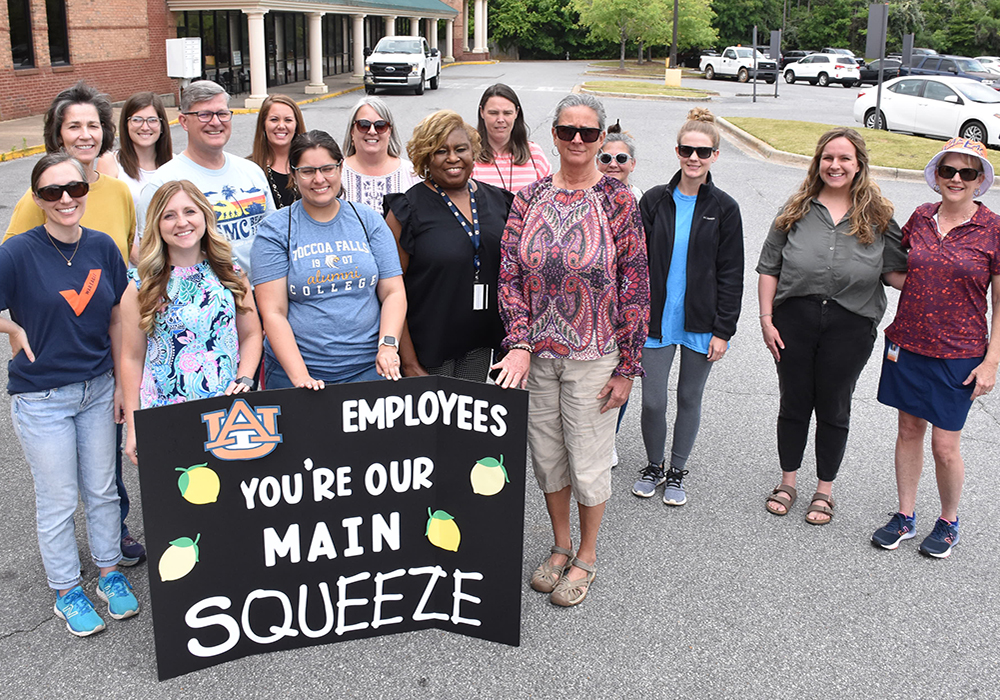 Large group of Auburn employees with sign