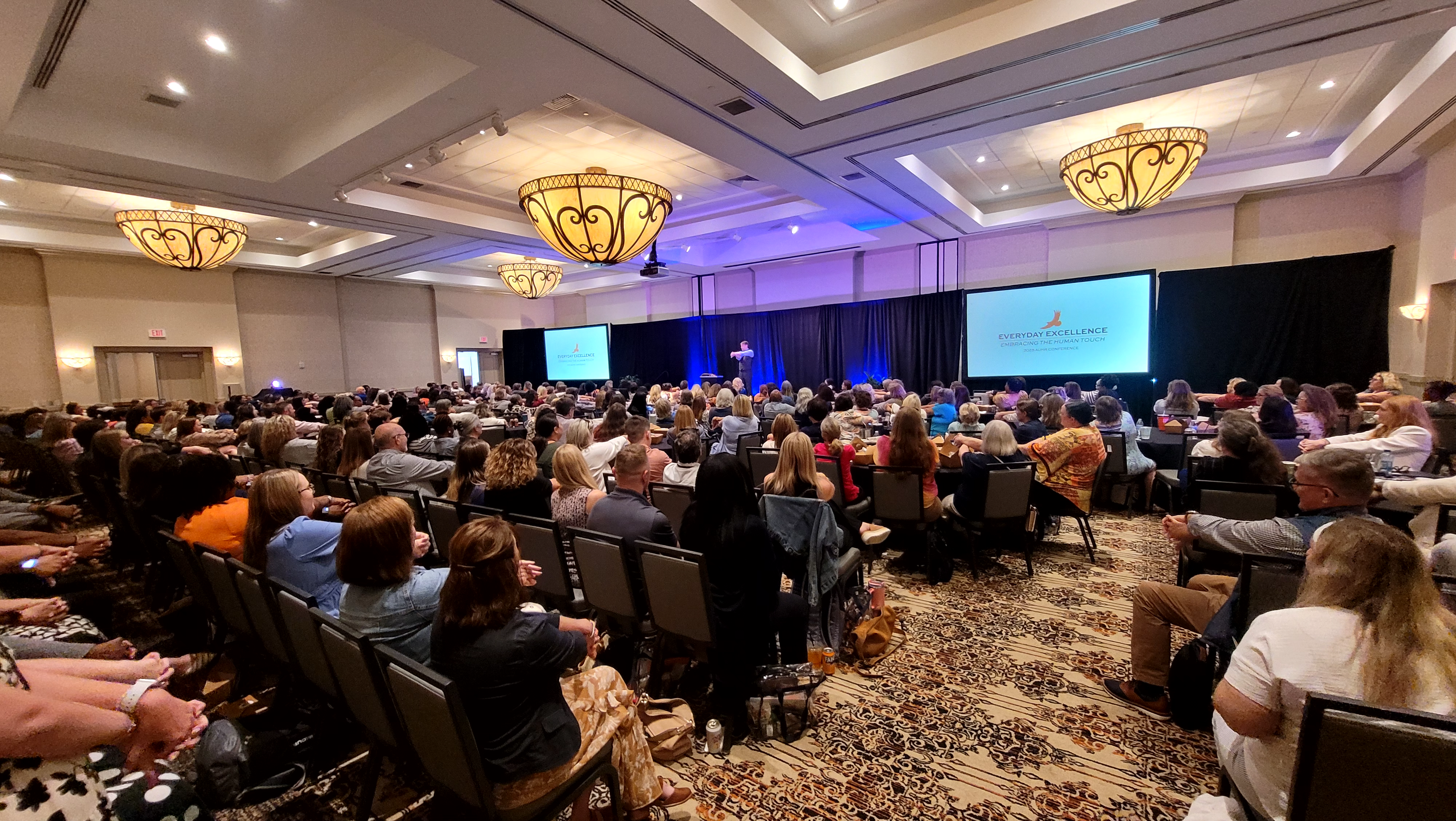 large audience listening to a conference speaker