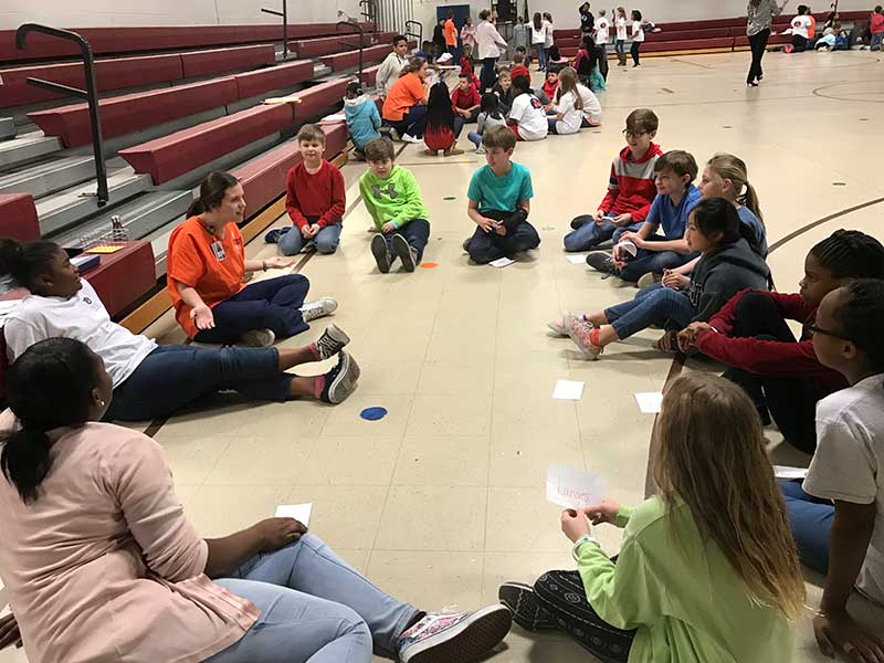 A nursing student talks to a group of children