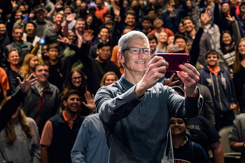 Tim Cook takes a selfie with an audience of students.
