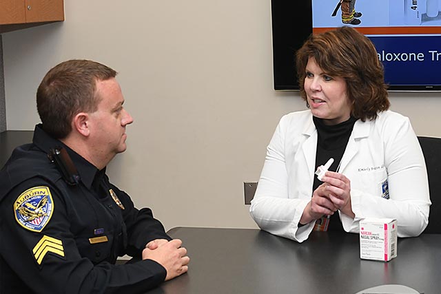 A doctor and police officer sit at a table