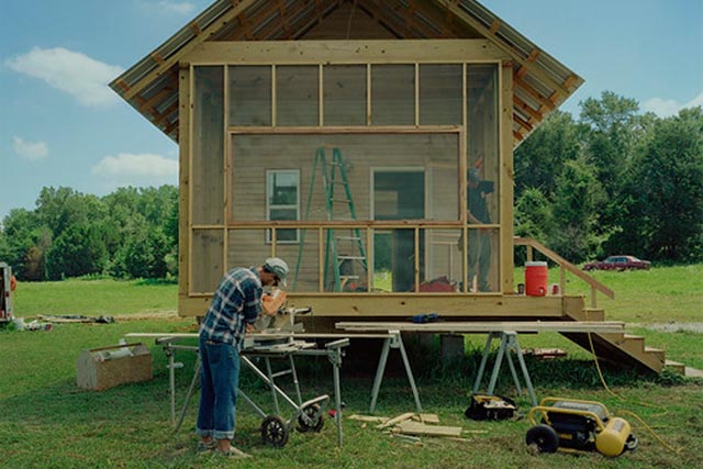A man it shown building a small structure
