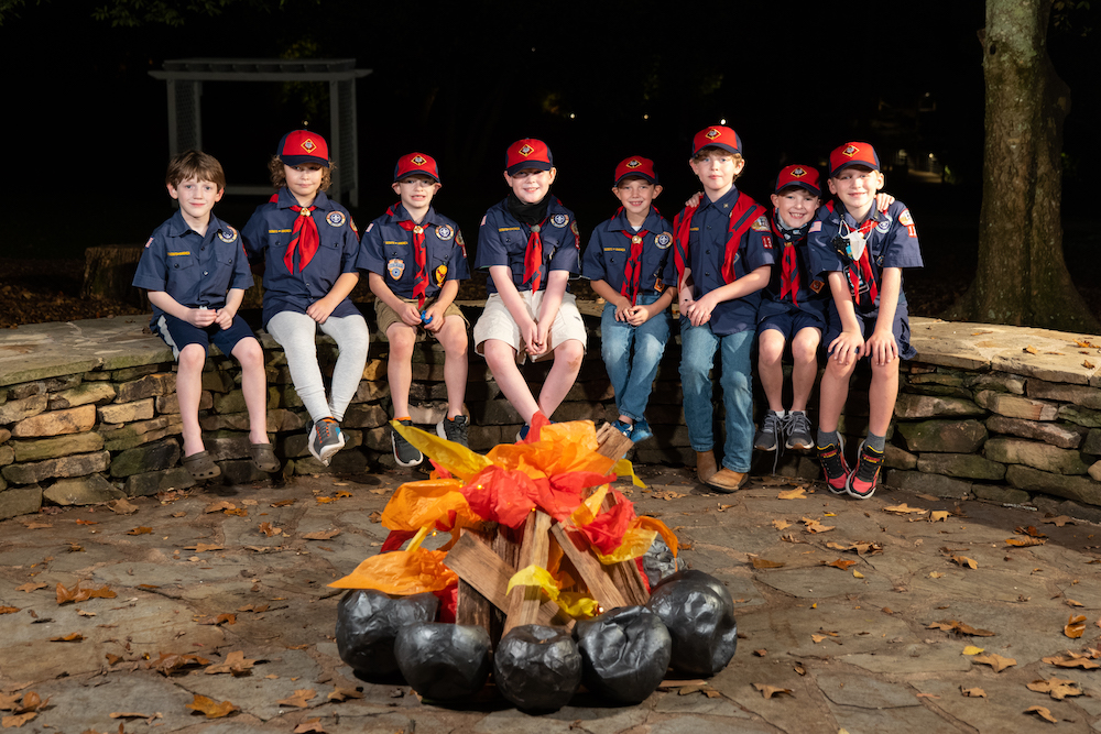 Group photo Boy Scouts sitting in front of a campfire