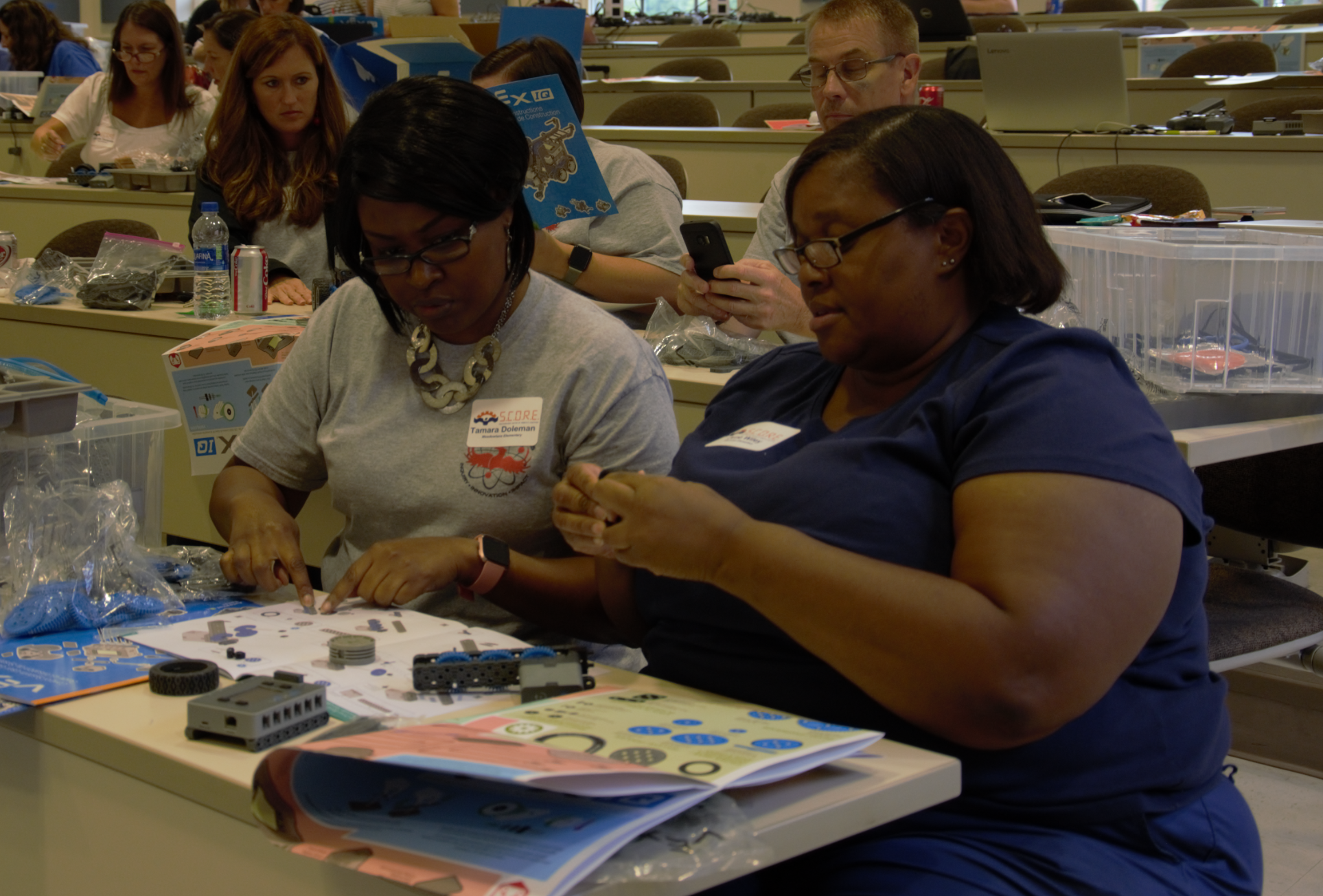 Two local teachers building a VEX-IQ robot.