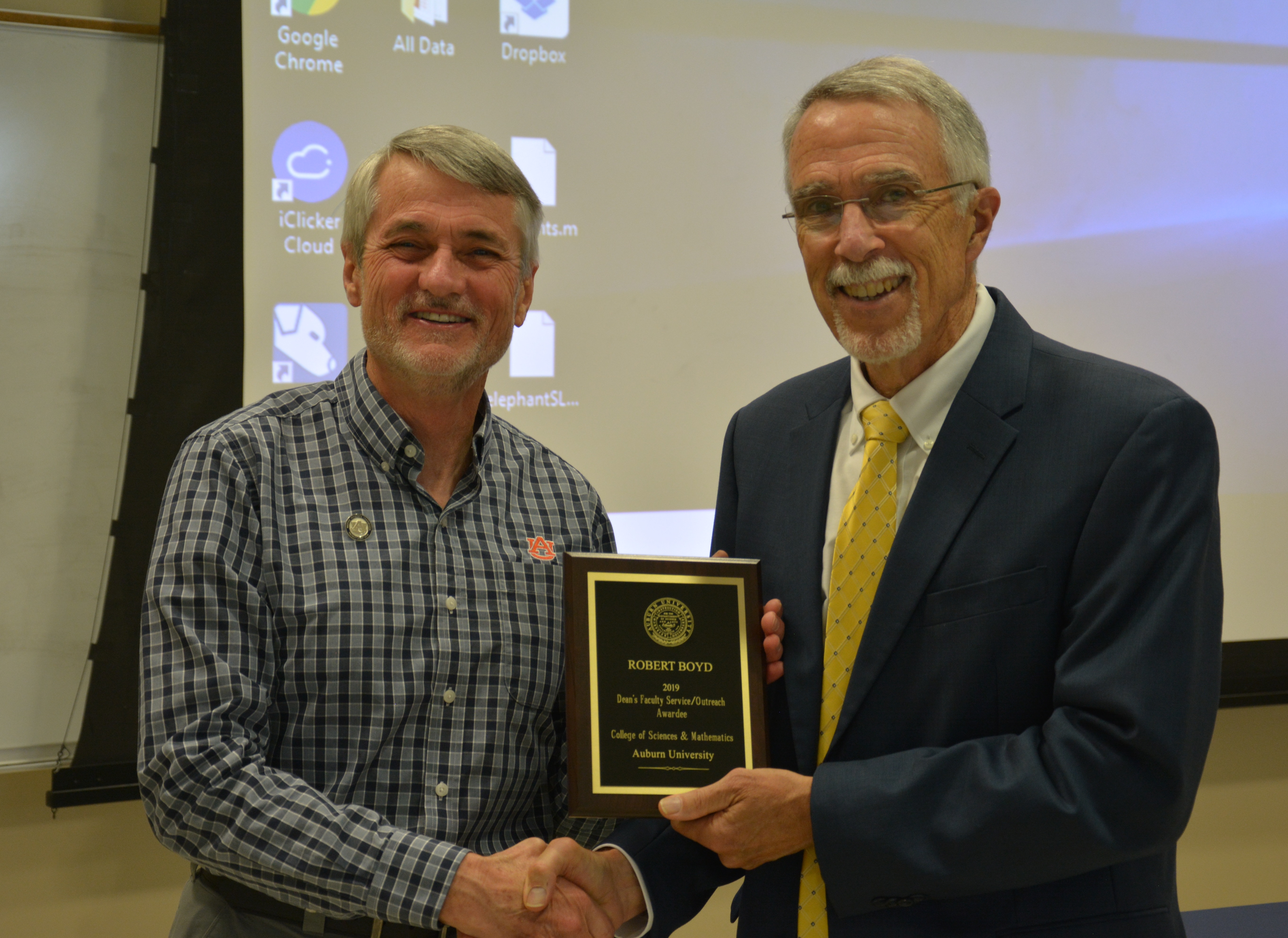 Dr. Robert Boyd, alumni professor in the Department of Biological Sciences and COSAM's new Associate Dean for Academic Affairs, receives a Faculty Service/Outreach Award from Dean Giordano.