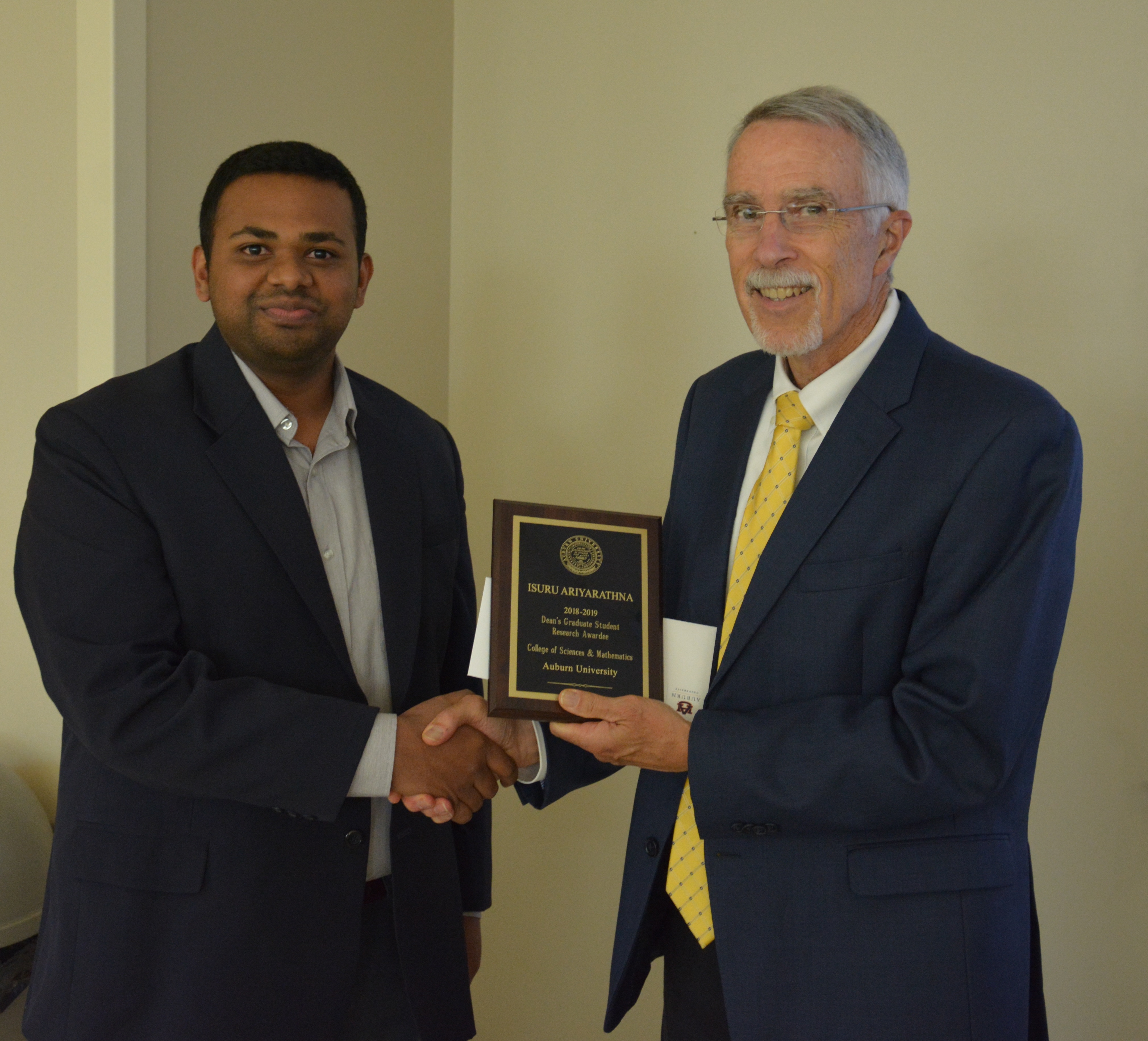 Doctoral student Isuru Ariyarathna accepting a Graduate Student Award from Dean Giordano.