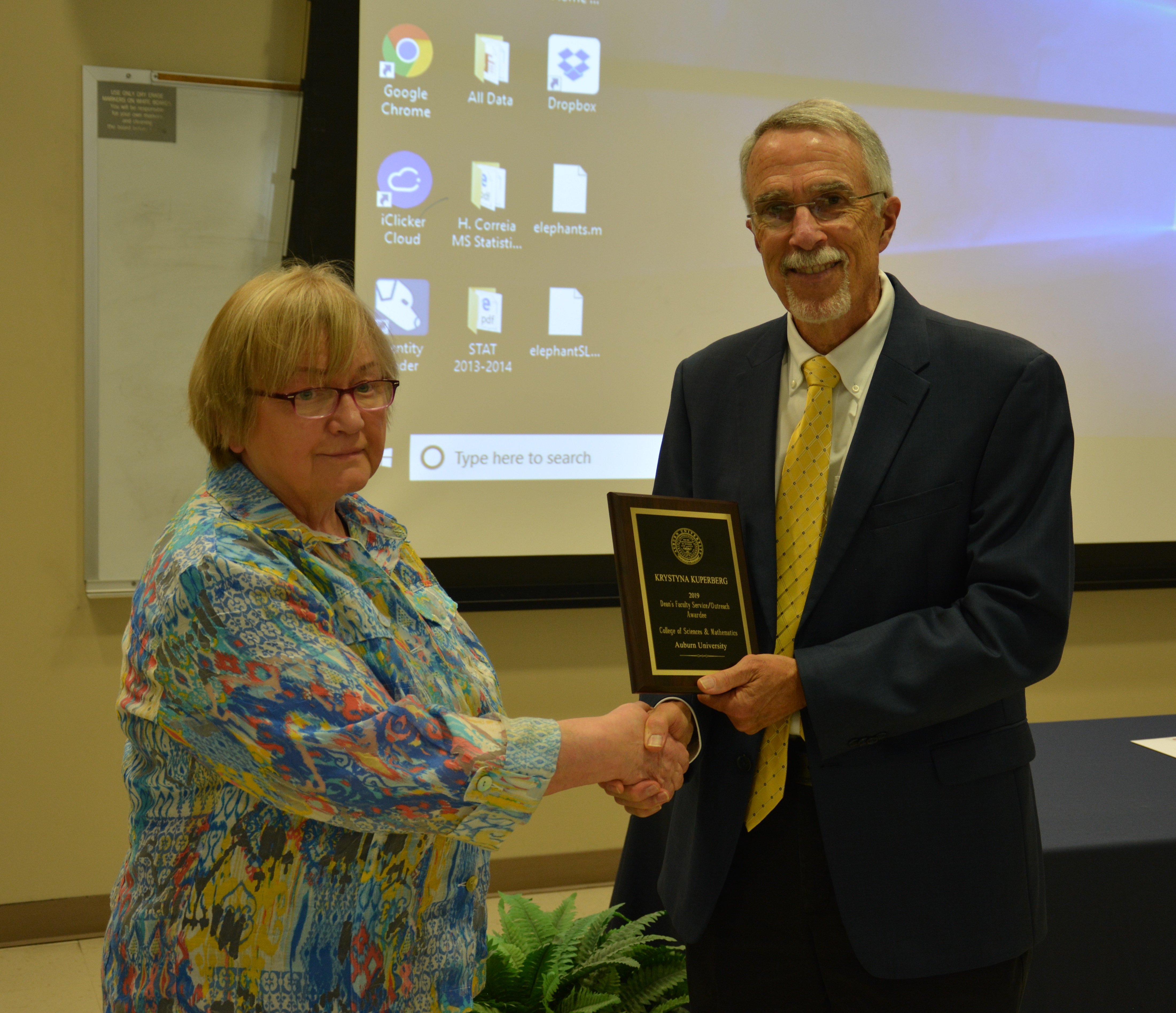 Dr. Krystyna Kuperberg, professor in the Department of Mathematics and Statistics, receives a Faculty Service/Outreach Award from Dean Giordano.