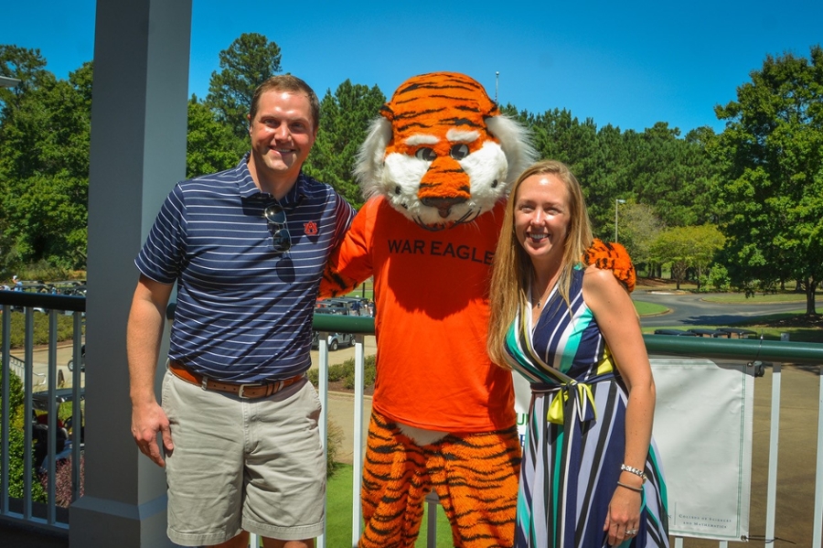 Dr. Erin T. Prince poses with Aubie and her husband at the  24th Annual Dean's Scholarship Golf Classic.