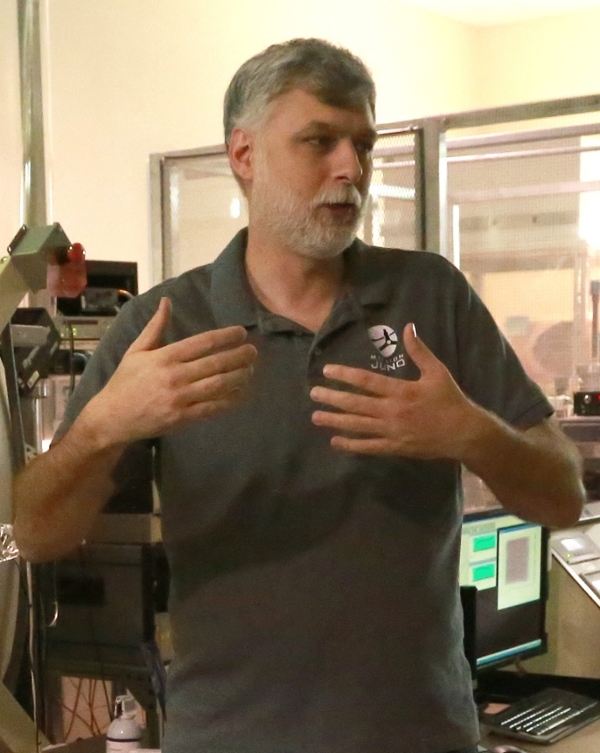 Valek is pictured in a laboratory at SwRI used for calibrating space science instruments. He is explaining how the equipment is used to simulate the space environment.