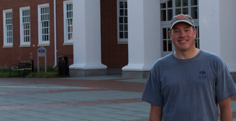 Chris Compton proudly wears an Auburn University hat and shirt in front of the Science Center at Washington and Lee University in Virginia.