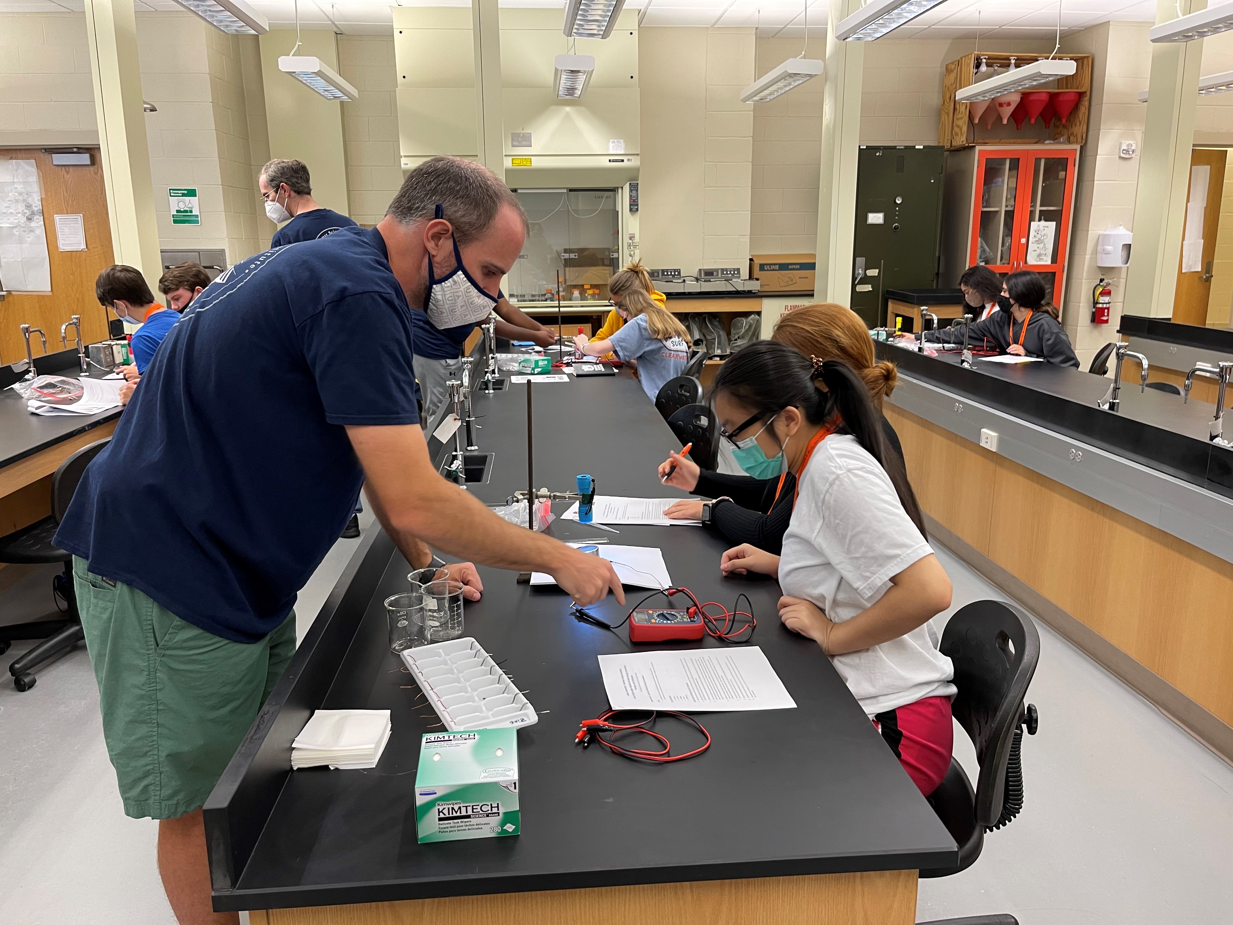 Tina Nguyen gets advice from Byron Farnum to create a battery during the Summer Science Institute. 